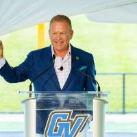 Brian Kelly speaking, holding up a fist at the Jamie Hosford Football Center dedication.